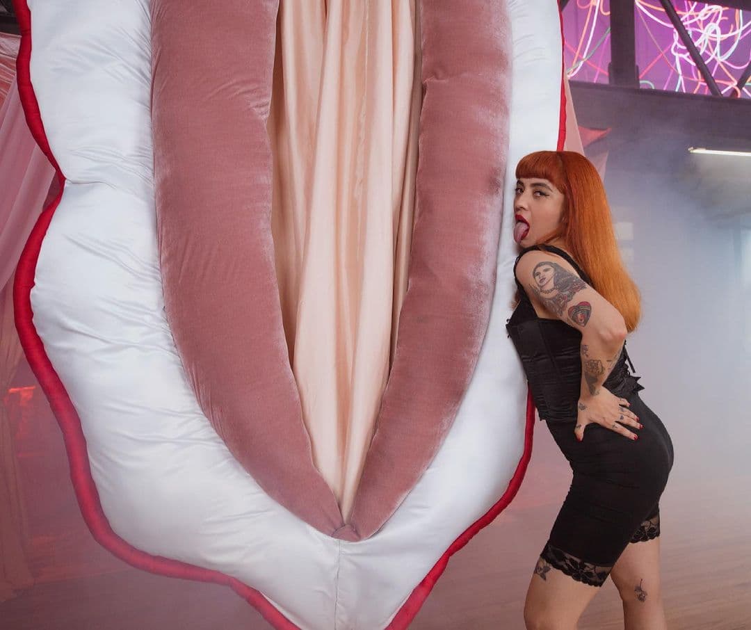 A lo largo de ésta, se desarrollan diferentes escenografías, entre las que se encuentran una vulva gigante de tela.