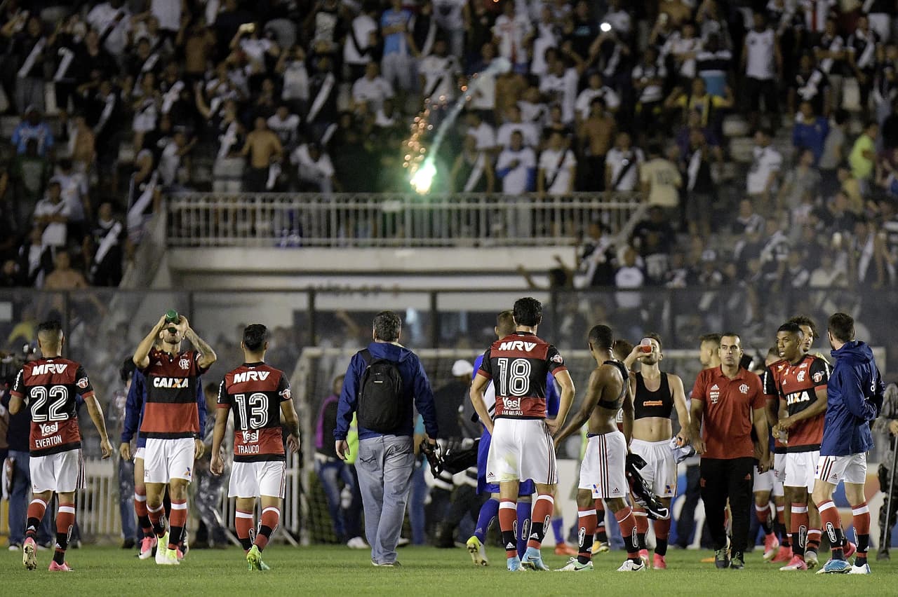 Desde las tribunas comenzaron a descender bengalas y otros artefactos pirotécnicos que comprometían la integridad física de los jugadores.