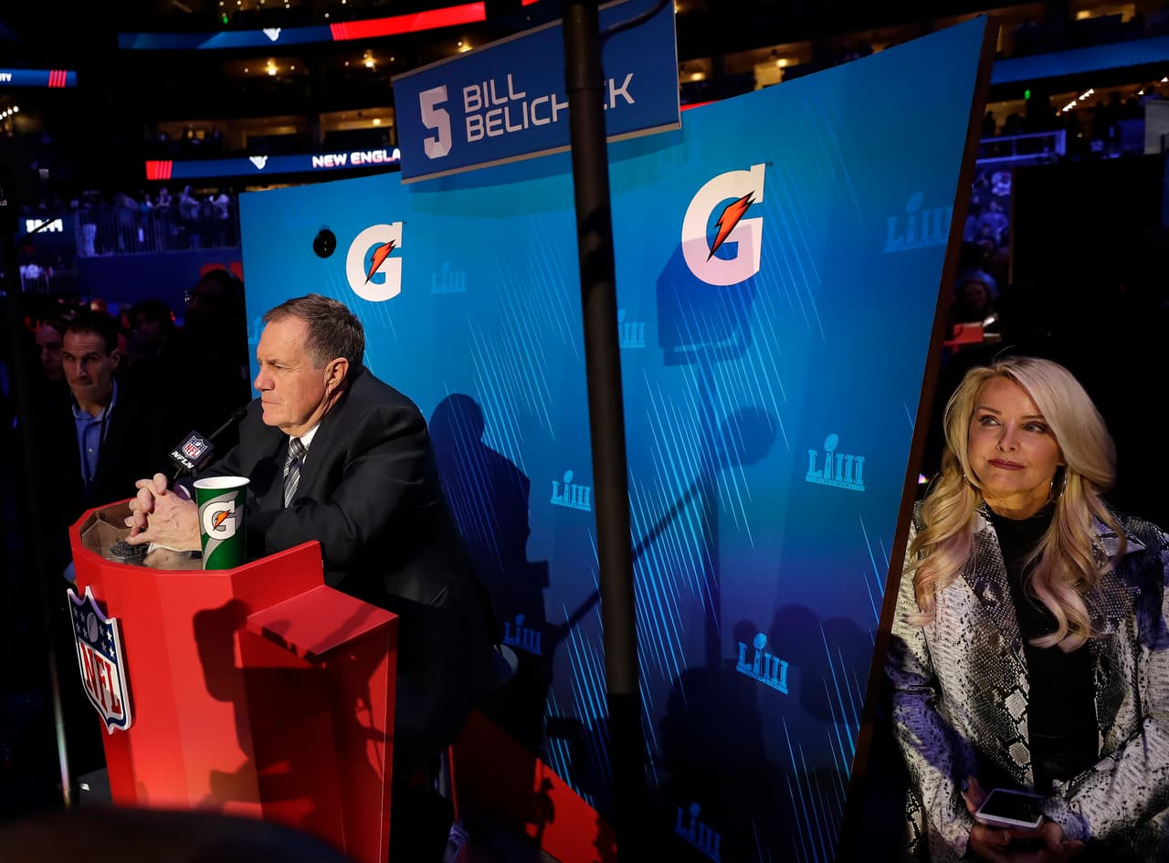 Linda Holliday, pareja de Bill Belichick, entrenador de los Pats, escucha las preguntas que le formulan al mandamás de New England.
