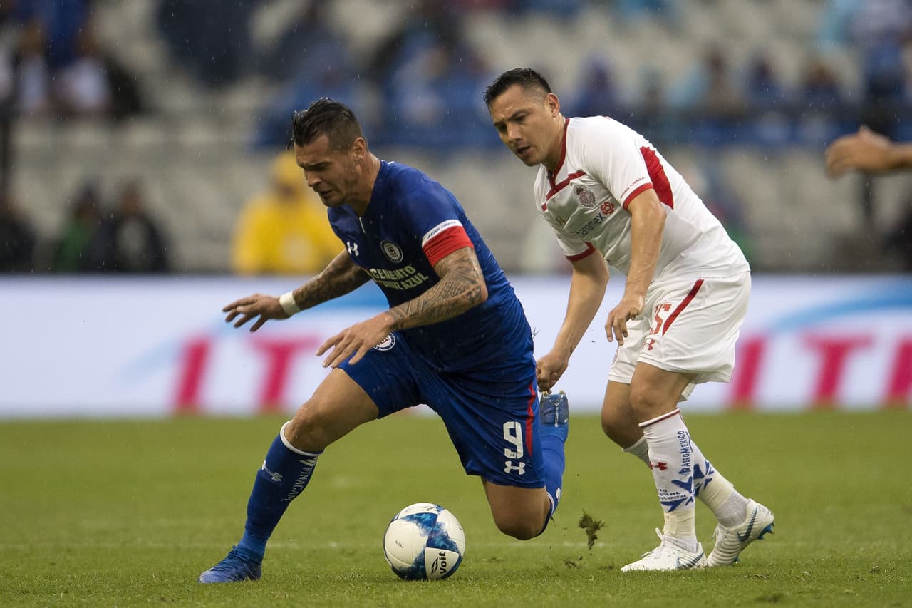 El argentino Milton Caraglio (9) muy asediado por Antonio Ríos (15), antes de salir lesionado en una jugada en la que chocó con un rival y sacó la peor parte. Fue cambiado a los 28 minutos.