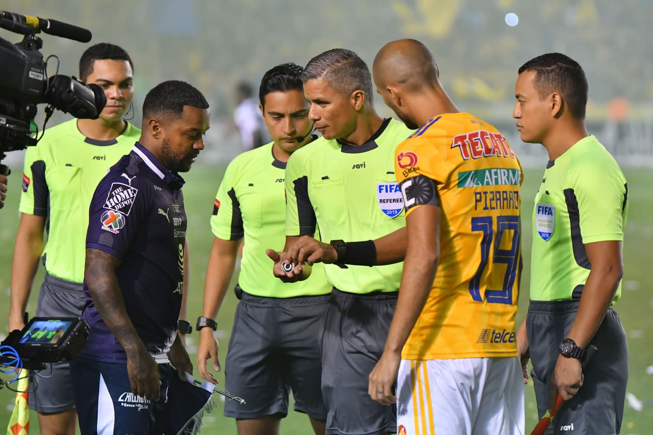 El protocolo de la ceremonia del lanzamiento de la moneda o volado. Tigres la ganó y sacó primero.