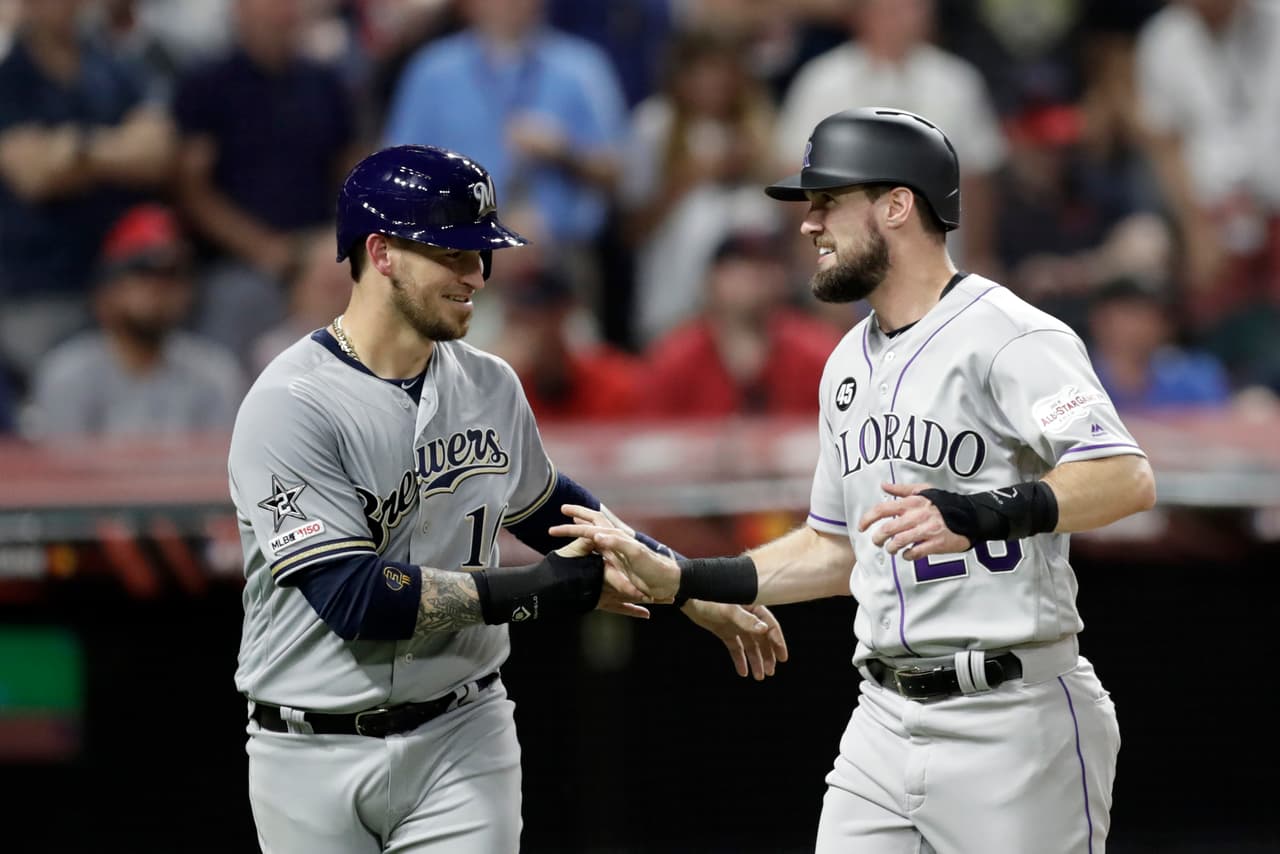 El cubano Yasmani Grandal, izquierda, de los Milwaukee Brewers, y David Dahl, de los Colorado Rockies, festejan después de pisar el home plate y apretar el partido 4-3, el drama quedaba para el final.