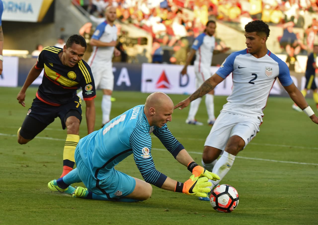 El portero de Estados Unidos, Brad Guzan, aleja la pelota del colombiano Carlos Bacca, junto al defensa estadounidense DeAndre Yedlin.