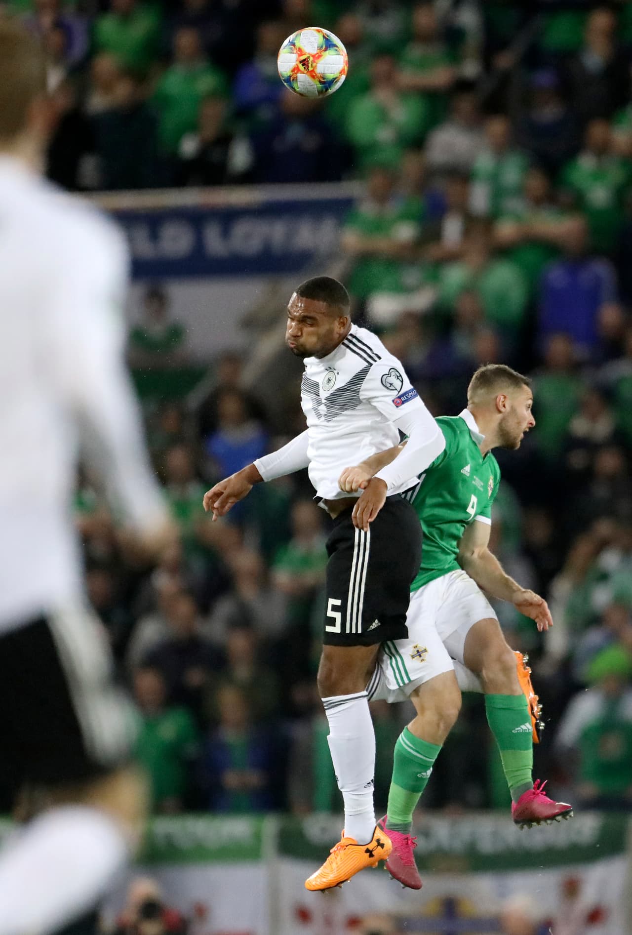 El defensor Jonathan Tah corta un centro de peligro al área.