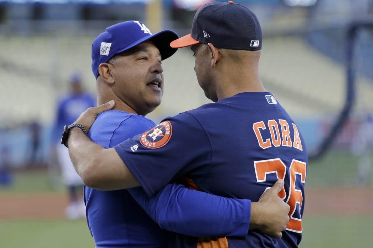 Dave Roberts, manager de los Dodgers, y Alex Cora, bench coach de los Astros, se abrazan en la previa al Juego 1.