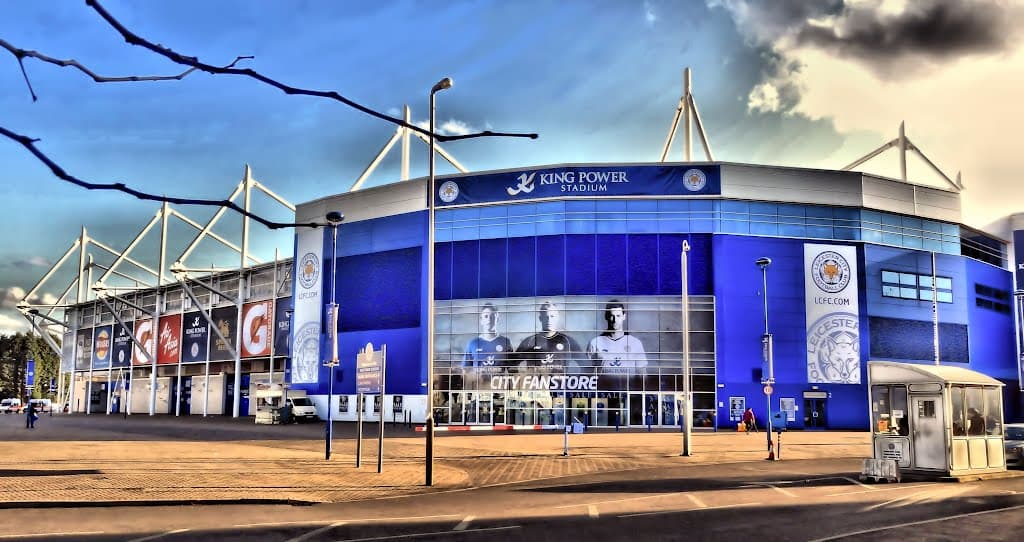 <b>Leicester City – King Power Stadium</b>
<br>Su ubicación como punto medio le favorece mucho, hace accesible su llegada desde cualquier punto del país; se encuentra lejos de la ciudad. Aunque el espacio es un poco más estrecho que los estadios de la ciudad, es buena opción. Hay 676 casos de COVID en la ciudad.