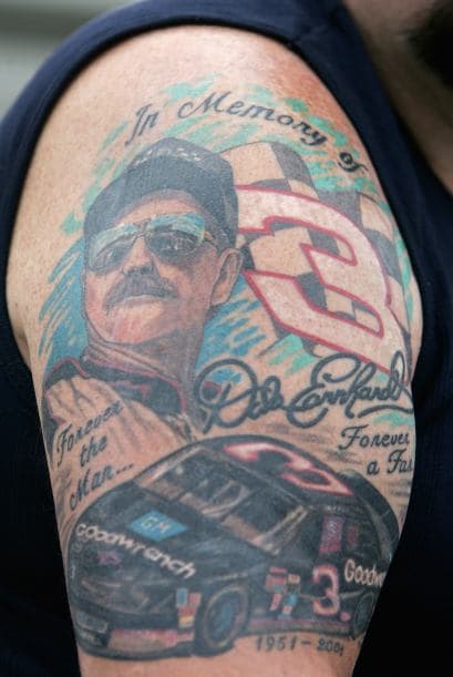 Un fanático con un tatuaje de Dale Earnhardt en su brazo mira la clasificación para la Copa Nextel de NASCAR Sylvania 300.