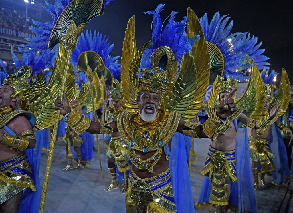 Princesas con plumas y alas, reyes y reinas con coronas giratorias, flores y soles andantes de colores tan vivos que iluminaban la noche... los desfiles de las tradicionales 'escolas' de samba regresaron con todo su esplendor tras una espera de más de dos años.