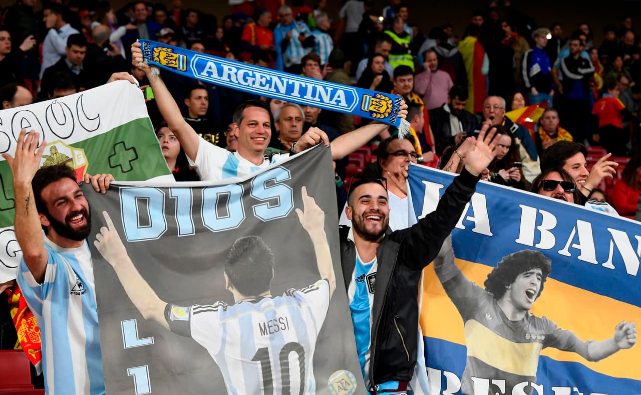 Argentina fans cheer with pictures of Argentina's forward Lionel Messi and Argentinian football legend Diego Maradona (R) ahead of a friendly football match between Spain and Argentina at the Wanda Metropolitano Stadium in Madrid on March 27, 2018. / AFP PHOTO / GABRIEL BOUYS (Photo credit should read GABRIEL BOUYS/AFP/Getty Images)
