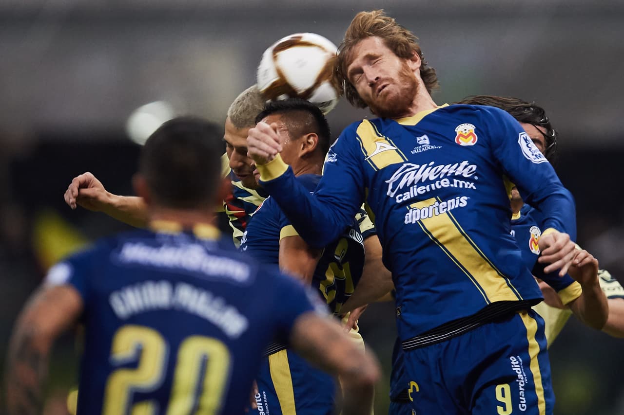 Aristeguieta intenta rematar a gol pero Guido Rodríguez lo evita bloqueando su cabezazo.