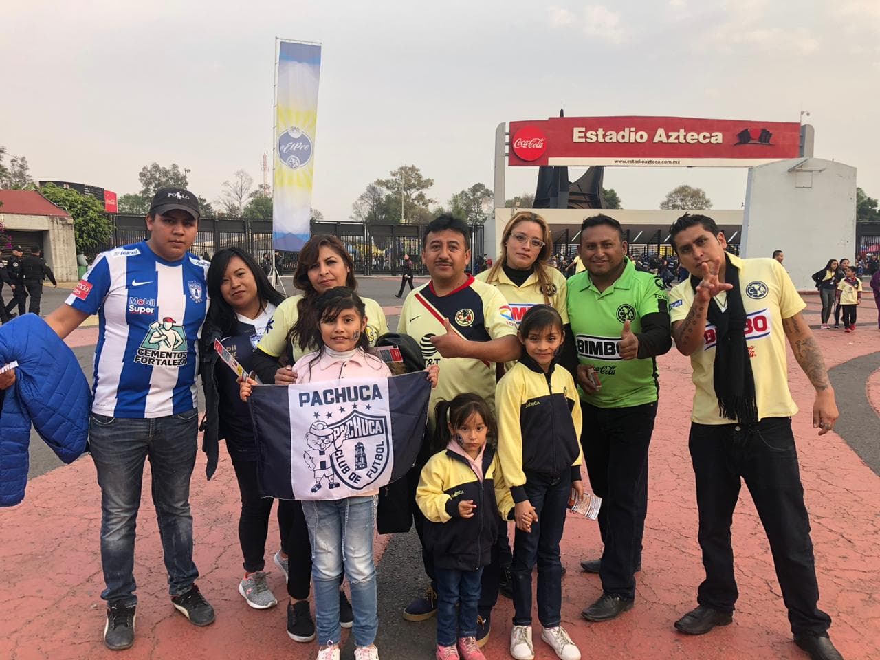 Una familia de fanáticos de América y Pachuca comparte afuera del Estadio Azteca antes del partido.