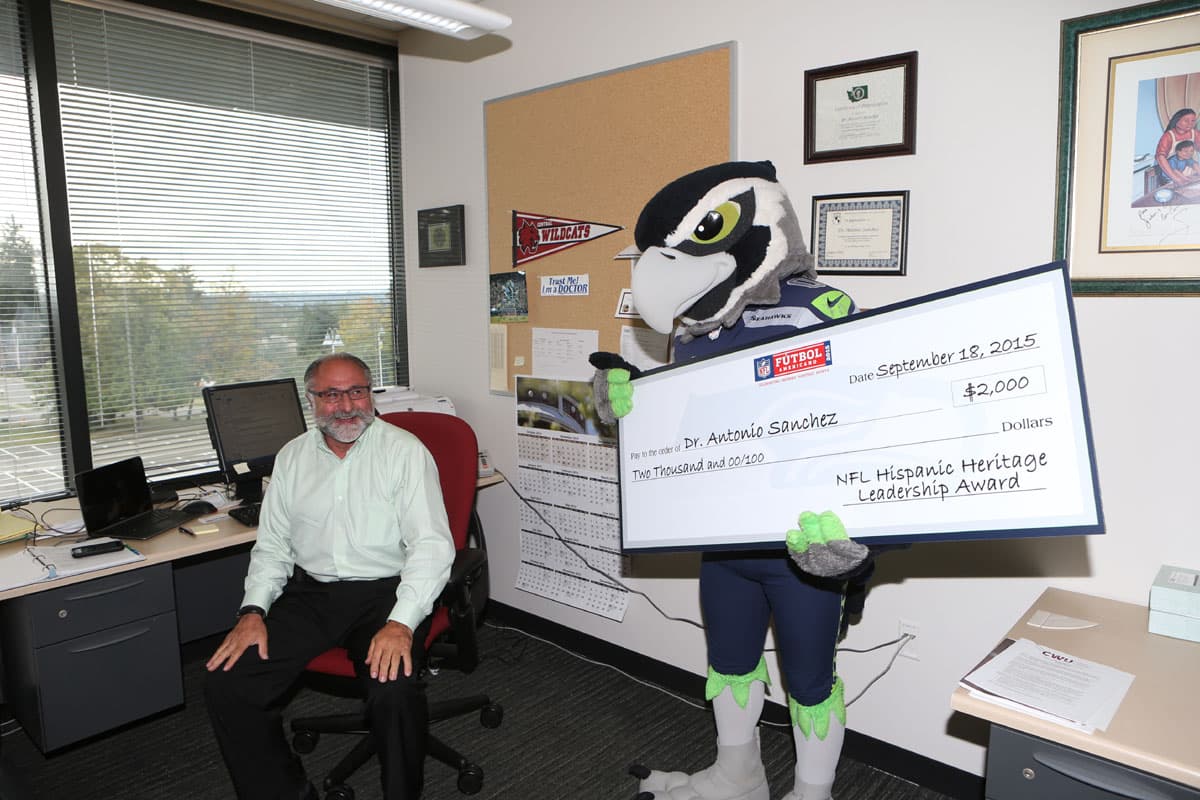 La mascota de los Seattle Seahawks, Blitz, le hizo una visita sorpresa a quien ganó el premio de Liderazgo de la Herencia Hispana por Seattle en este 2015, el Dr. Antonio Sánchez.