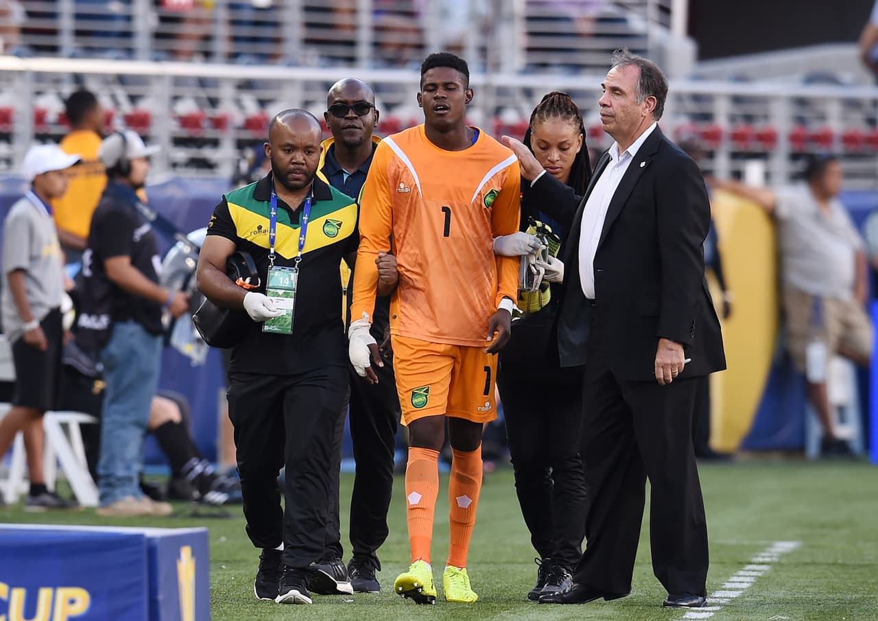 El técnico rival Bruce Arena consoló al arquero jamaicano cuando se dirigía a la banca. Una lesión nunca es oportuna, pero una final es el peor momento posible.