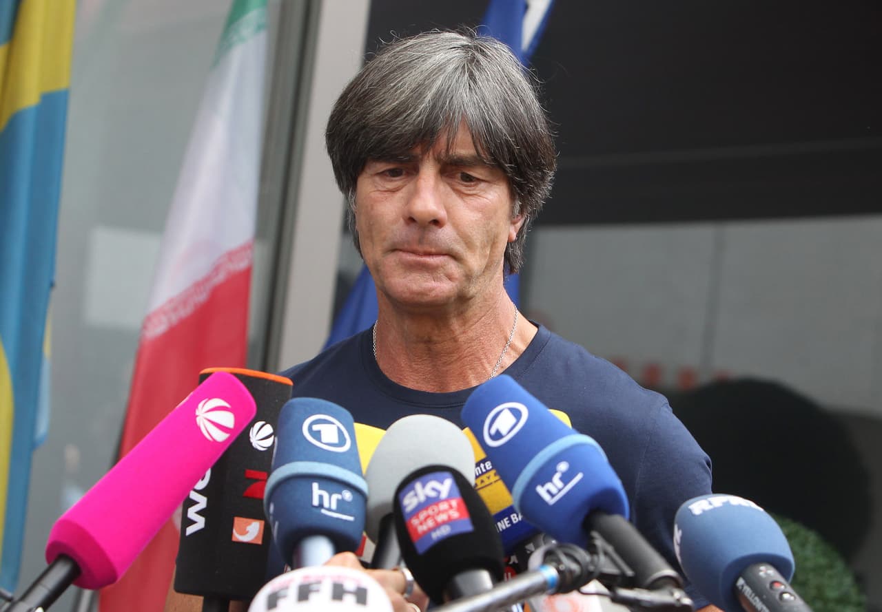 TOPSHOT - Germany's head coach Joachim Loew talks to media as he arrives at Frankfurt international airport on June 28, 2018, after flying back from Moscow following the German national football team's defeat in the Russia 2018 football World Cup. - Germany's embattled national team braced for a cold homecoming on June 28, 2018 after a shock World Cup exit that has plunged the football-mad nation into mourning and leaves the future of coach Joachim Loew in the balance. (Photo by Daniel ROLAND / AFP) (Photo credit should read DANIEL ROLAND/AFP/Getty Images)