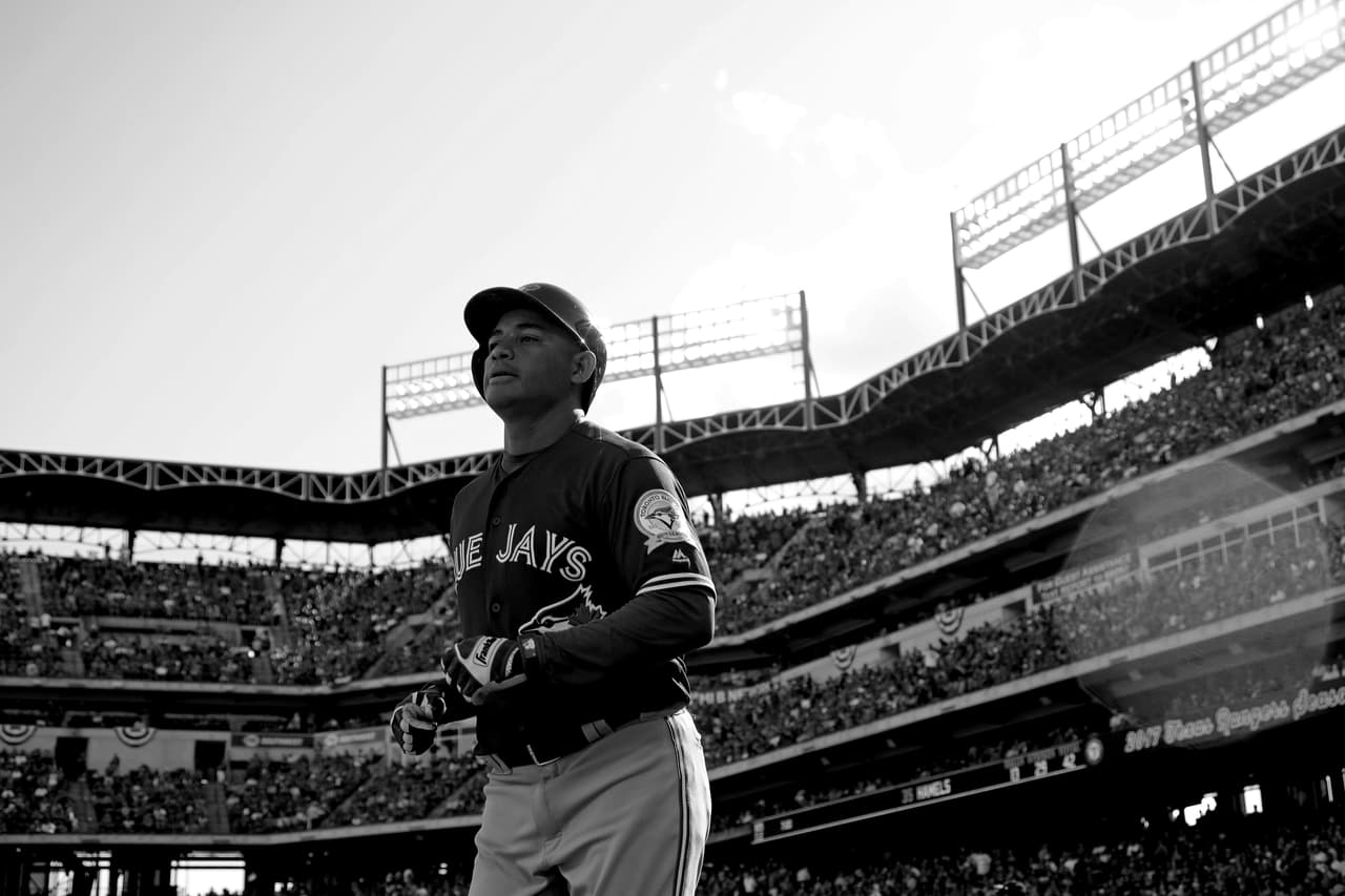 En una imagen convertida a blanco y negro, Ezequiel Carrera celebrando su anotación contra Rangers en el primer juego de postemporada de la MLB.