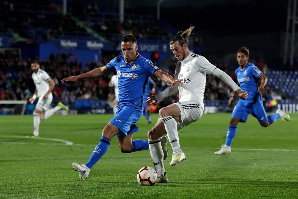 El galés Gareth Bale (der) jalando del gatillo buscando anotar para la causa del Real Madrid en acciones de la primera parte, ante la marcación de Bruno González del Getafe.