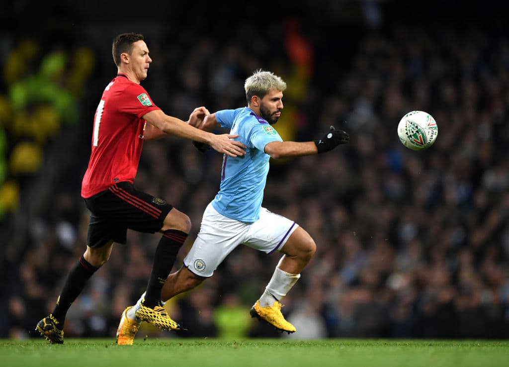 Sergio Aguero del Manchester City es atacado por Nemanja Matic del Manchester United en búsqueda del balón.