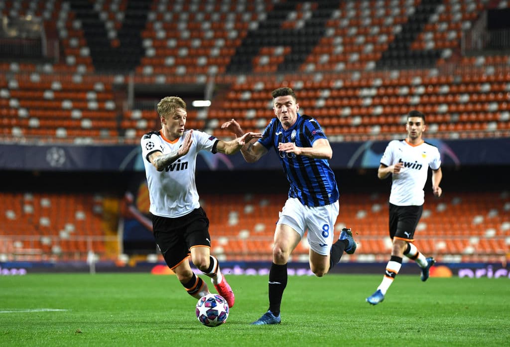 Daniel Wass y Robin Gosens pelean por la posesión del esférico. El balón es para el del Valencia.