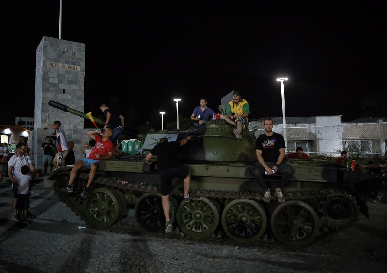Red Star fans pose in front of a former Yugoslav army T-55 tank parked at the northern grandstand of the Rajko Mitic stadium in Belgrade on August 27, 2019. - Red Star Belgrade fans stirred controversy after parking an army tank outside their stadium ahead of their Champions League play-off second leg against Swiss side Young Boys on August 27, 2019. The tank, a refurbished T-55 purchased from an army depot, was parked outside the stadium as an "attraction", the Serbian club said on their Facebook page. (Photo by OLIVER BUNIC / AFP) (Photo credit should read OLIVER BUNIC/AFP/Getty Images)
