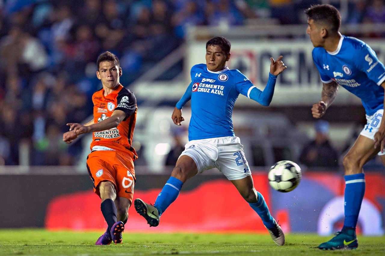 Hirving Lozano (izquierda) contra jugadores de Cruz Azul.