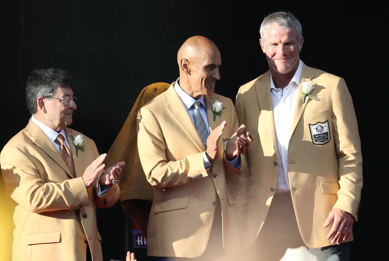 Hall of Fame enshrinees Eddie DeBartolo Jr., Tony Dungy and Brett Favre look on during the Pro Football Hall of Fame enshrinement ceremony at the Tom Benson Hall of Fame Stadium in Canton, Ohio on Aug. 6, 2016. (Ben Liebenberg via AP)