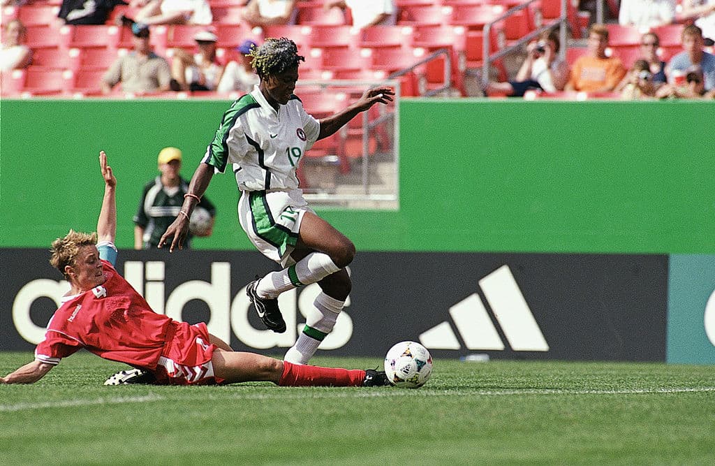 Lene Terp (4) de Dinamarca se barre para quitarle el balón a Mercy Akide (19) de Nigeria en el Mundial Femenino de 1999 en Estados Unidos, en partido que se llevó a cabo en el entonces llamado Jack Cooke Kent Stadium en Landover, Maryland. Esa vez Nigeria venció 2-0 a Dinamarca.