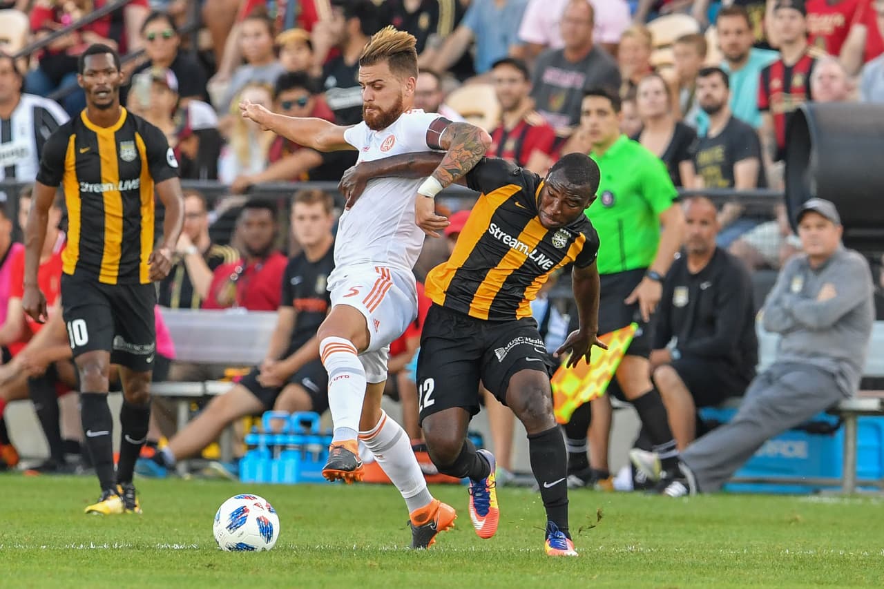 Jun 6, 2018; Kennesaw, GA, USA; Atlanta United defender Leandro Gonzalez (5) and Charleston Battery midfielder Brian Anunga (22) fight for the ball during the first half at Fifth Third Bank Stadium. Mandatory Credit: Dale Zanine-USA TODAY Sports