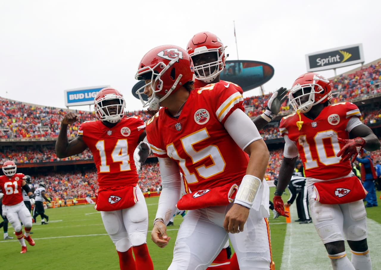 Kansas City Chiefs quarterback Patrick Mahomes (15) celebrates a touchdown with offensive lineman Cam Erving (75) and wide receiver Sammy Watkins (14) during the first half of an NFL football game against the Jacksonville Jaguars in Kansas City, Mo., Sunday, Oct. 7, 2018. (AP Photo/Charlie Riedel)