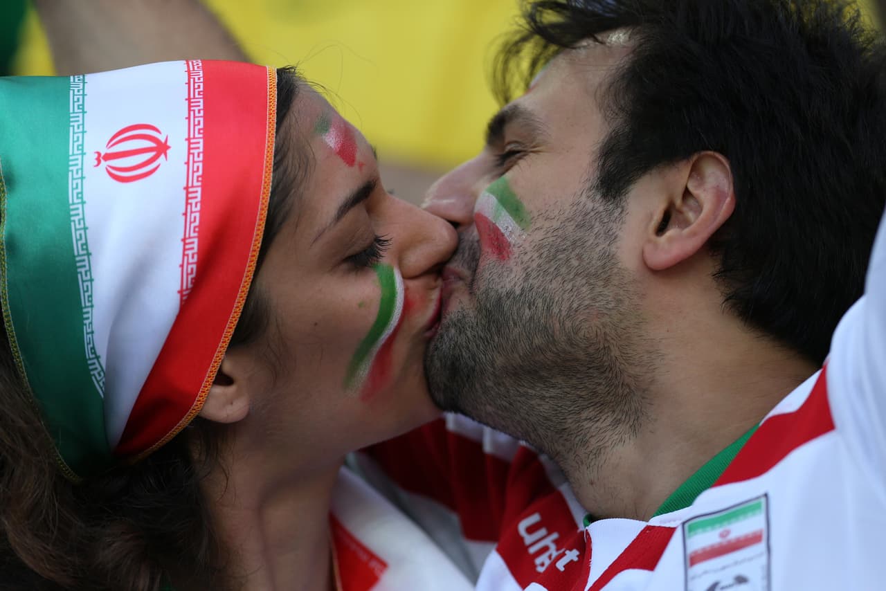 An Iranian couple kiss before the start of the Group F football match between Iran and Nigeria at the Baixada Arena in Curitiba during the 2014 FIFA World Cup on June 16, 2014. AFP PHOTO / BEHROUZ MEHRI (Photo credit should read BEHROUZ MEHRI/AFP/Getty Images)