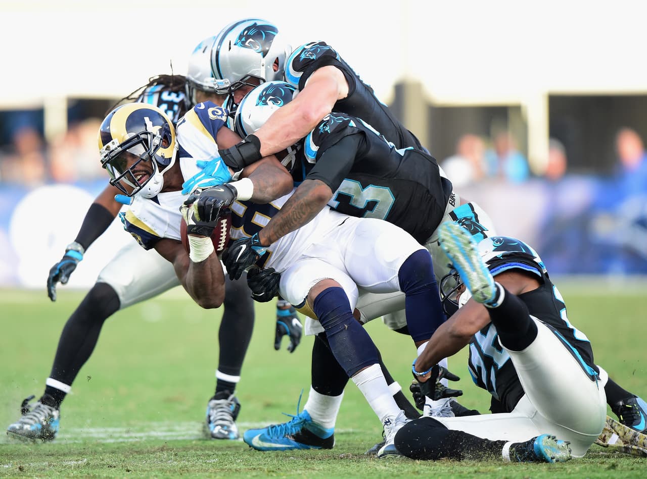 Una montaña de defensivos de Caroñina le cayeron al receptor de los Rams, Kenny Britt.