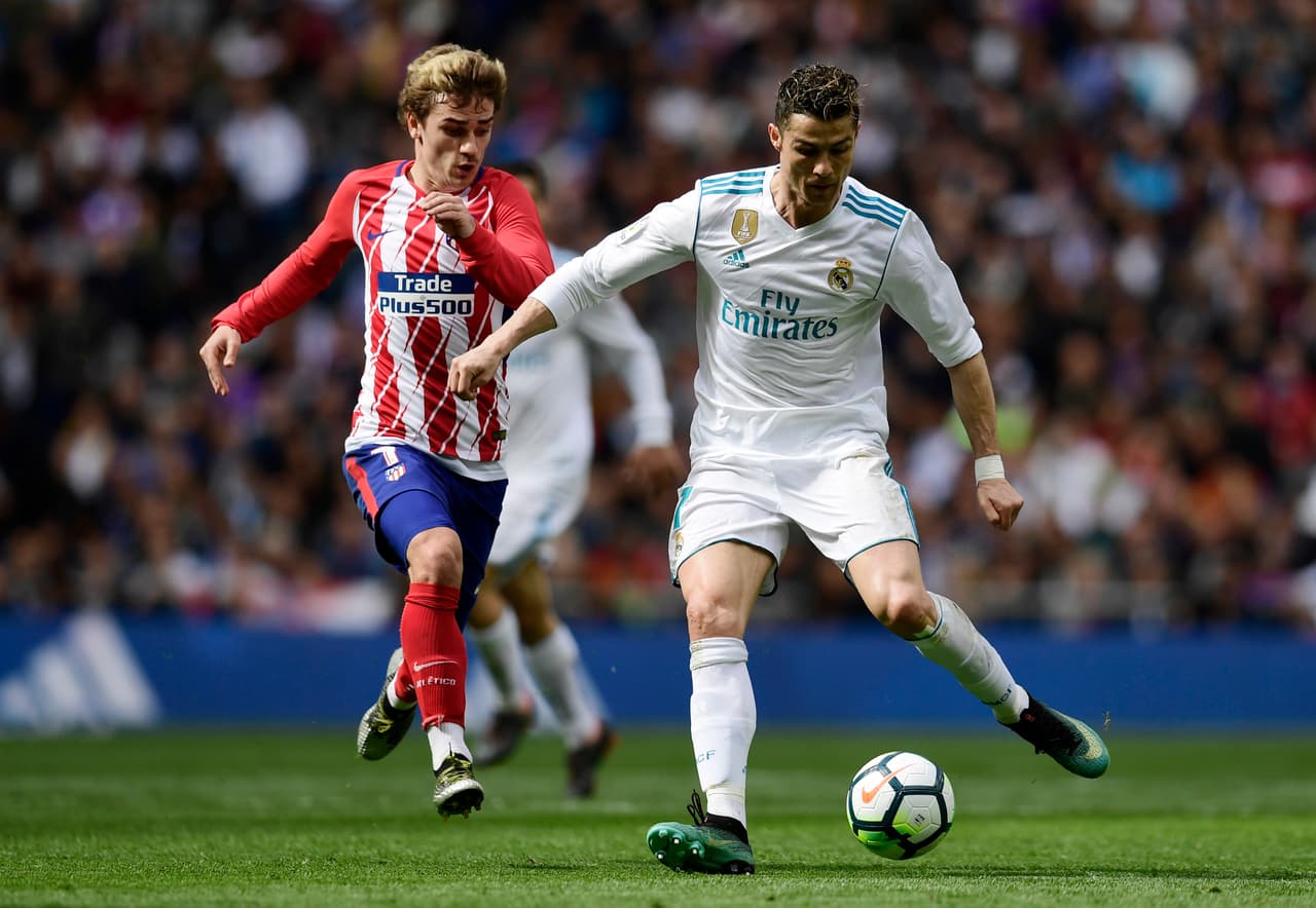 Real Madrid's Portuguese forward Cristiano Ronaldo (R) vies with Atletico Madrid's French forward Antoine Griezmann during the Spanish league football match between Real Madrid CF and Club Atletico de Madrid at the Santiago Bernabeu stadium in Madrid on April 8, 2018. / AFP PHOTO / JAVIER SORIANO (Photo credit should read JAVIER SORIANO/AFP/Getty Images)