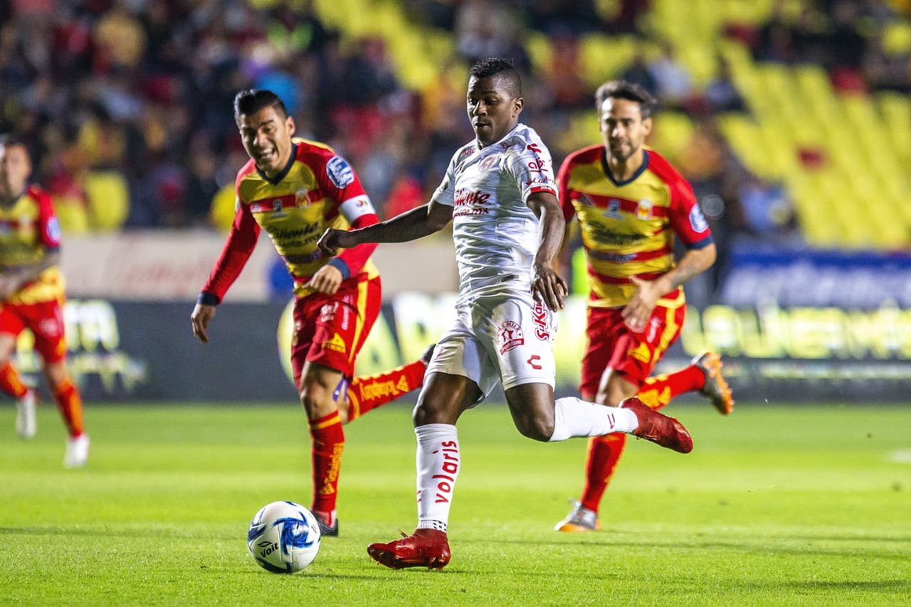 Miller Bolaños filtra un balón para Camilo Sanvezzo pero es cortado por la defensa.