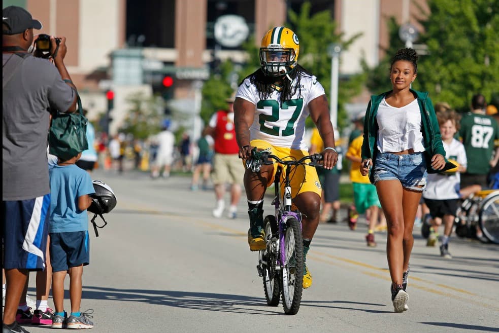 También el corredor Eddie Lacy se presentó en bicicleta al campo de prácticas de los Packers. Lacy debe llegar a los entrenamientos con menor peso corporal.
