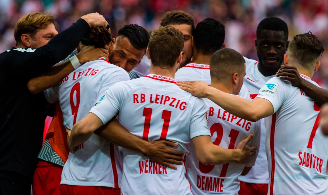 Leipzi players celebrate with Leipzig's head coach Ralph Hasenhuettl after Leipzig's Danish forward Yussuf Poulsen scored during the Bundesliga match RB Leipzig vs Bayern Munich in Leipzig on May 13, 2017. Bayern came from behind to win 5 to 4 in the dying minutes of the match. / AFP PHOTO / John MACDOUGALL / RESTRICTIONS: DURING MATCH TIME: DFL RULES TO LIMIT THE ONLINE USAGE TO 15 PICTURES PER MATCH AND FORBID IMAGE SEQUENCES TO SIMULATE VIDEO. == RESTRICTED TO EDITORIAL USE == FOR FURTHER QUERIES PLEASE CONTACT DFL DIRECTLY AT + 49 69 650050 (Photo credit should read JOHN MACDOUGALL/AFP/Getty Images)
