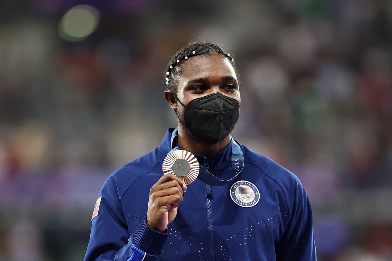 TOPSHOT - Bronze medallist US' Noah Lyles celebrates on the podium during the victory ceremony for the men's 200m athletics event during the Paris 2024 Olympic Games at Stade de France in Saint-Denis, north of Paris, on August 9, 2024. (Photo by Anne-Christine POUJOULAT / AFP) (Photo by ANNE-CHRISTINE POUJOULAT/AFP via Getty Images)
