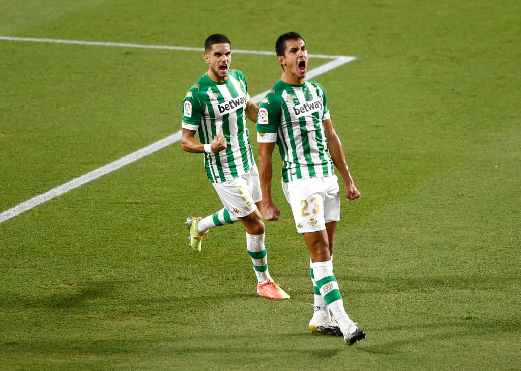 SEVILLE, SPAIN - SEPTEMBER 26: Aissa Mandi of Real Betis celebrates with teammate Marc Bartra after scoring his team's first goal during the La Liga Santader match between Real Betis and Real Madrid at Estadio Benito Villamarin on September 26, 2020 in Seville, Spain. Sporting stadiums in Spain remain under strict restrictions due to the Coronavirus Pandemic as Government social distancing laws prohibit fans inside venues resulting in games being played behind closed doors. (Photo by Fran Santiago/Getty Images)