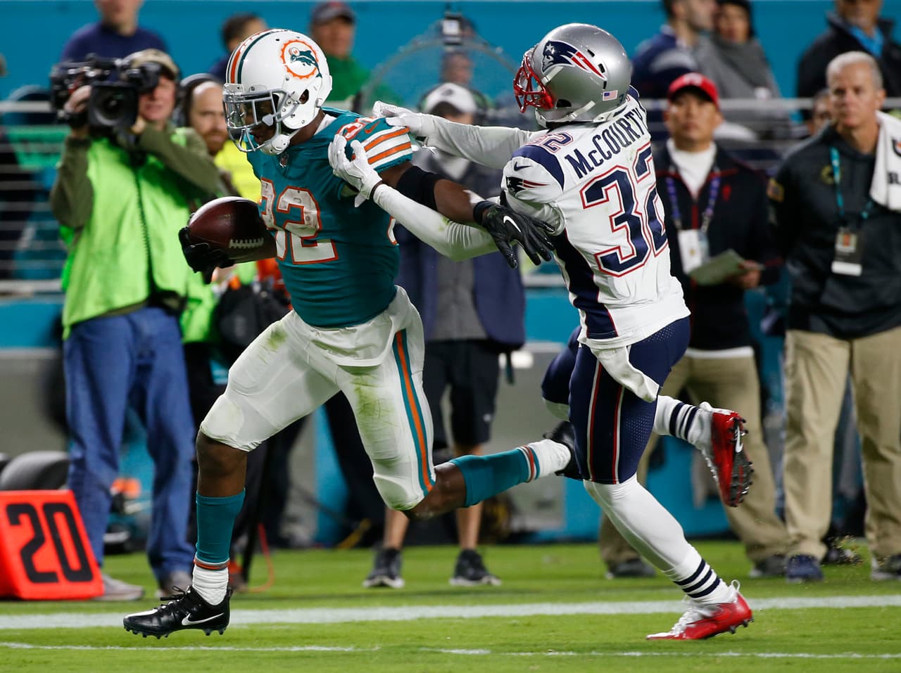 New England Patriots free safety Devin McCourty (32) attempts to stop Miami Dolphins running back Kenyan Drake (32), during the second half of an NFL football game, Monday, Dec. 11, 2017, in Miami Gardens, Fla. (AP Photo/Wilfredo Lee)