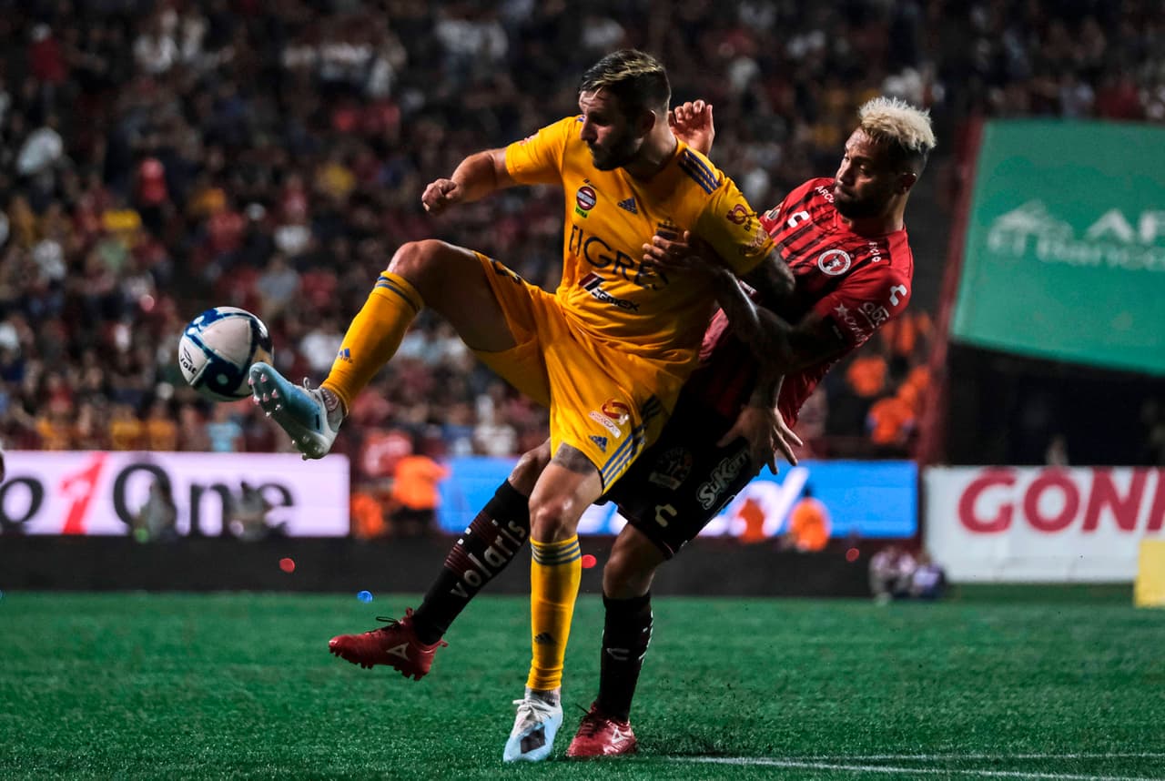 Gignac le gana a Julian Velázquez la disputa por el balón.