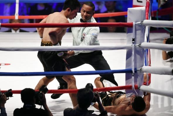 EL referí Héctor Afú separa a a Miura luego mientras Dib se desploma sobre la lona.