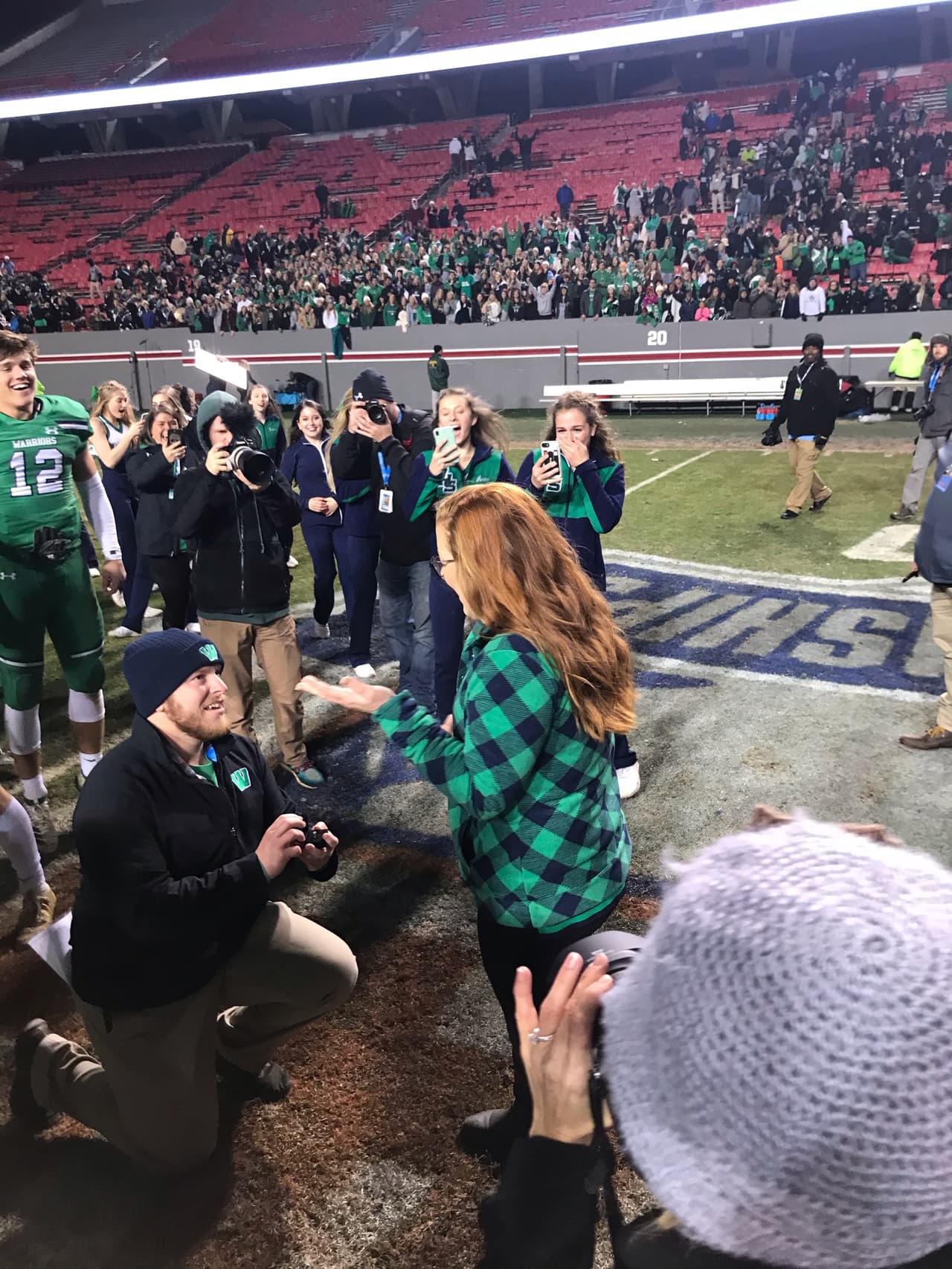 Entrenador de fútbol americano le pide matrimonio a su novia en el campo de juego