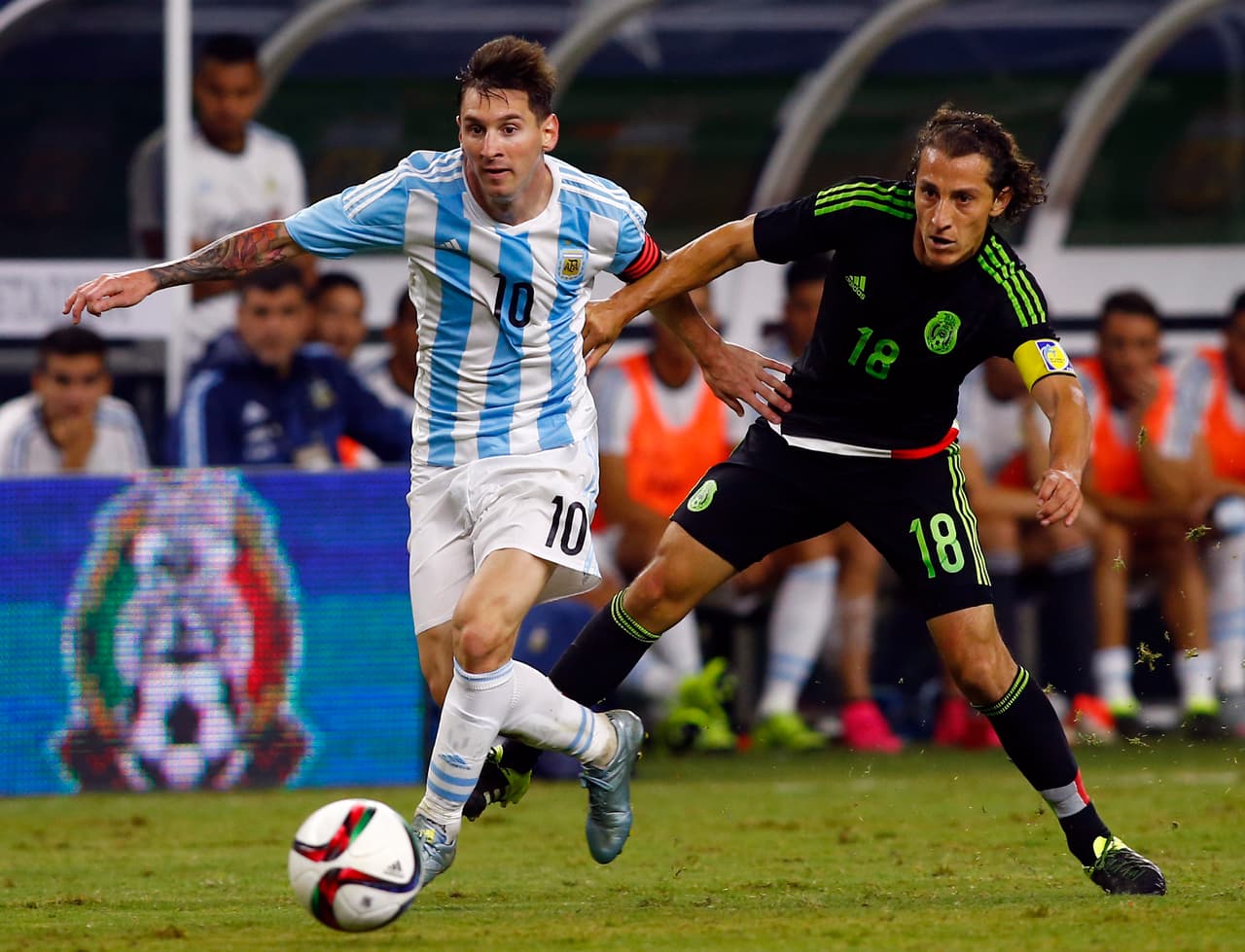 Lionel Messi enfrentando a Andrés Guardado.