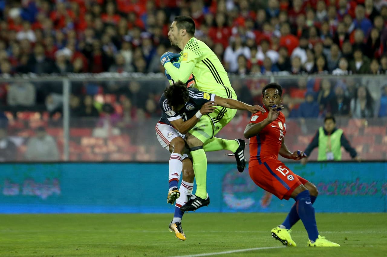 Paraguay goalkeeper Anthony Silva, center, catches the ball next to his teammate Oscar Romero, as Chile's Jean Beausejour looks on, during a 2018 World Cup qualifying soccer match in Santiago, Chile, Thursday, Aug. 31, 2017. (AP Photo/Esteban Felix)