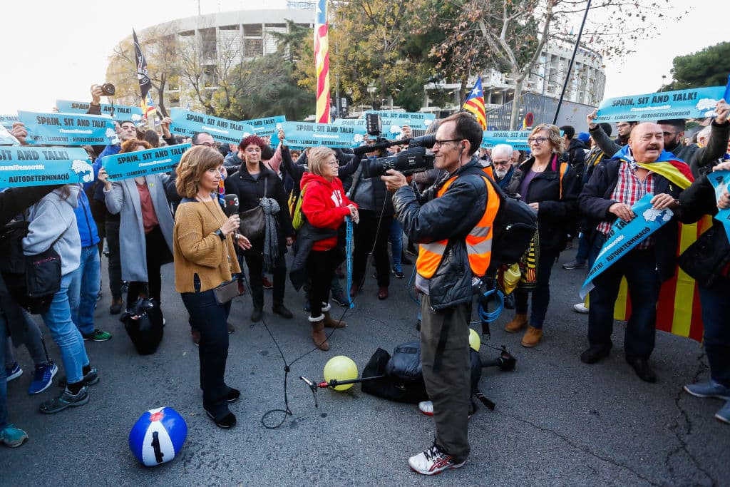 La gente acude al Camp Nou con las cartulinas de 'Spain, sit and talk' y banderas esteladas, de forma pacífica.