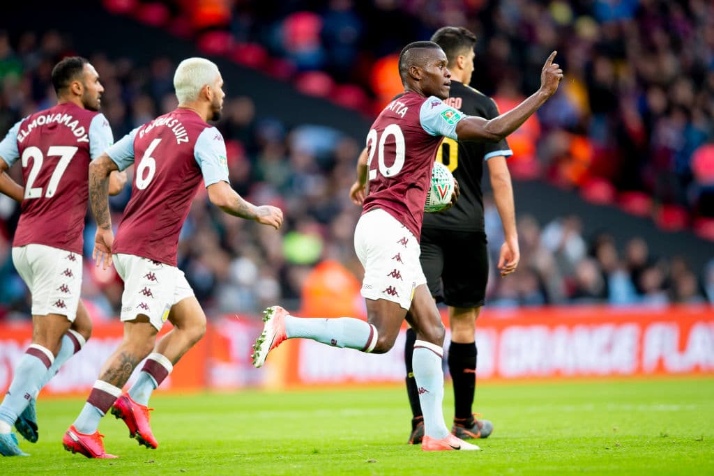Los jugadores del Aston Villa corren, con Mbwana Samatta, para festejar el gol, mientras el anotador toma la pelota y la regresa al centro del campo.