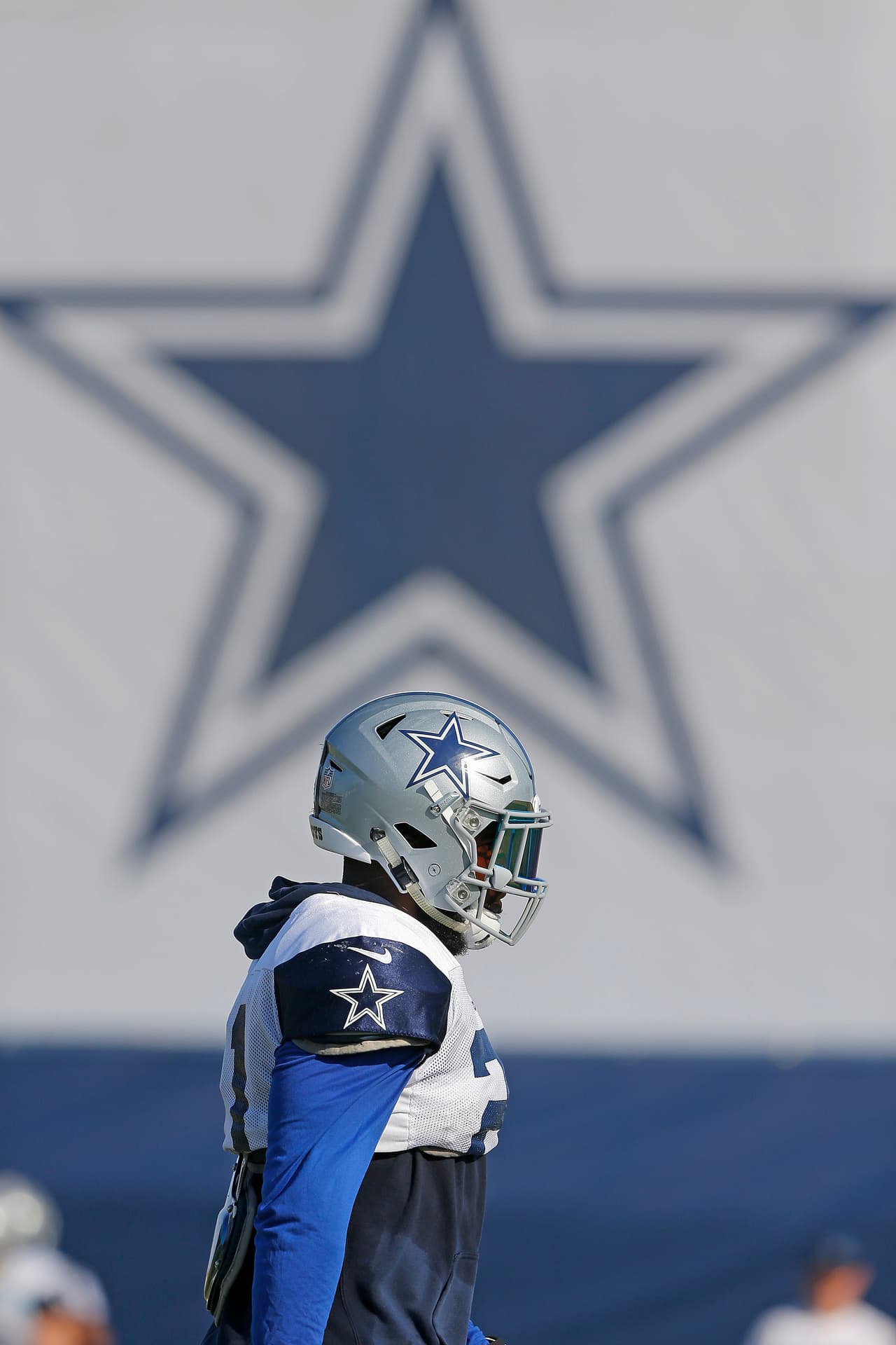 Dallas Cowboys running back Ezekiel Elliott (21) walks under a star in the background during an NFL training camp, Wednesday, August 9, 2017 in Oxnard, California. (James D Smith via AP)