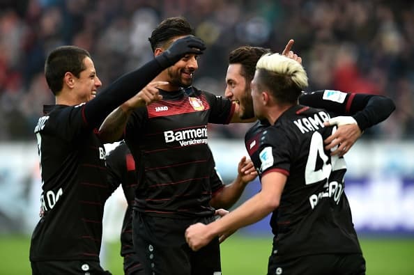 Leverkusen's midfielder Hakan Calhanoglu and his teammates celebrate during the German first division Bundesliga football match of Bayer Leverkusen vs Hertha BSC Berlin in Leverkusen, western Germany, on January 22, 2017. / AFP / PATRIK STOLLARZ / RESTRICTIONS: DURING MATCH TIME: DFL RULES TO LIMIT THE ONLINE USAGE TO 15 PICTURES PER MATCH AND FORBID IMAGE SEQUENCES TO SIMULATE VIDEO. == RESTRICTED TO EDITORIAL USE == FOR FURTHER QUERIES PLEASE CONTACT DFL DIRECTLY AT + 49 69 650050 (Photo credit should read PATRIK STOLLARZ/AFP/Getty Images)