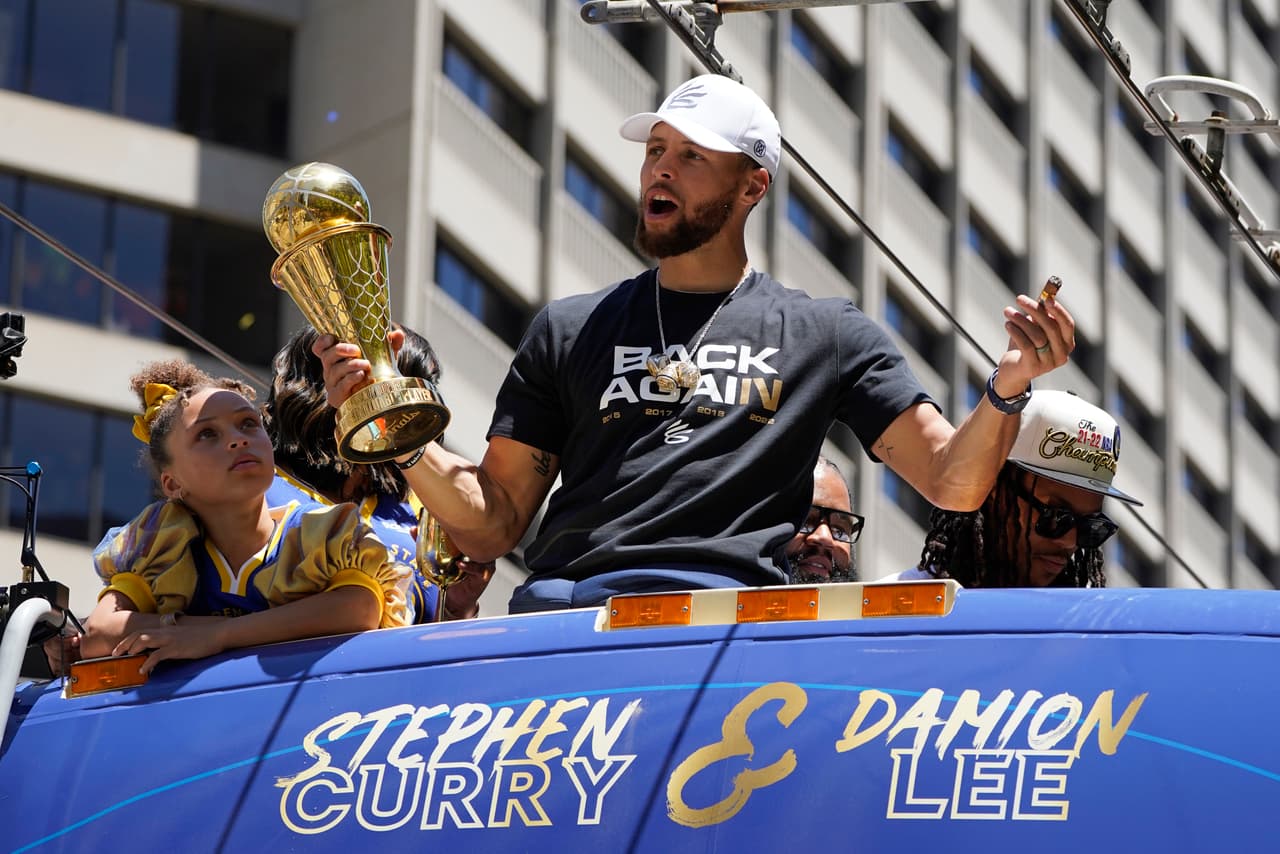 Stephen Curry, de los Golden State Warriors, se sube a un autobús durante el desfile del campeonato de la NBA en San Francisco, el lunes 20 de junio de 2022. (AP Photo/Eric Risberg)