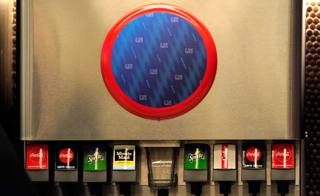 Aquí se aprecia una máquina despachadora de refrescos en el Mercedes-Benz Stadium con bebidas de Coca Cola pero su logo se halla cubierto por un gran sticker con motivos del SB LIII.