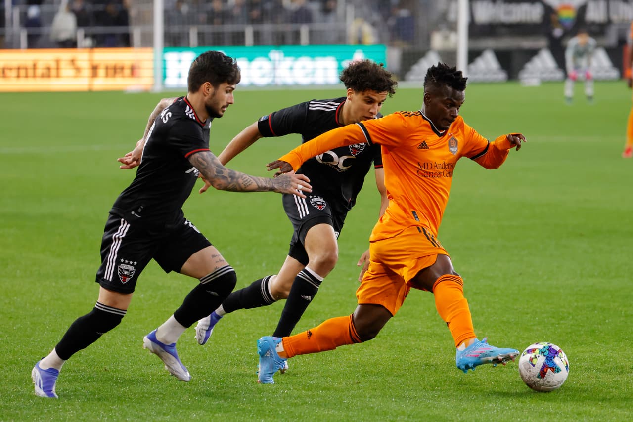May 7, 2022; Washington, District of Columbia, USA; Houston Dynamo forward Carlos Darwin Quintero (23) dribbles the ball as D.C. United forward Taxiarchis Fountas (11) and D.C. United midfielder Sofiane Djeffal (13) chase in the first half at Audi Field. Mandatory Credit: Geoff Burke-USA TODAY Sports