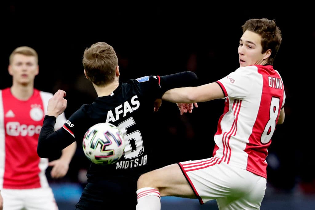 Fredrik Midtsjo pierde el balón con Carel Eiting en un duelo aéreo.